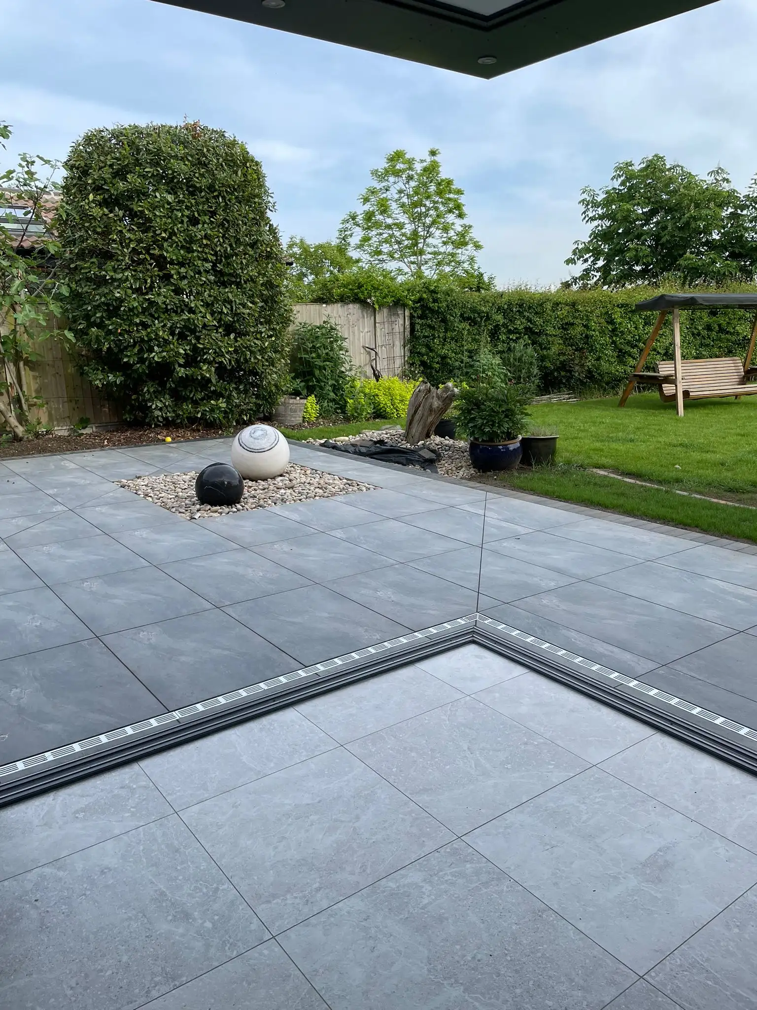 Porcelain patio with pebble beds and planting